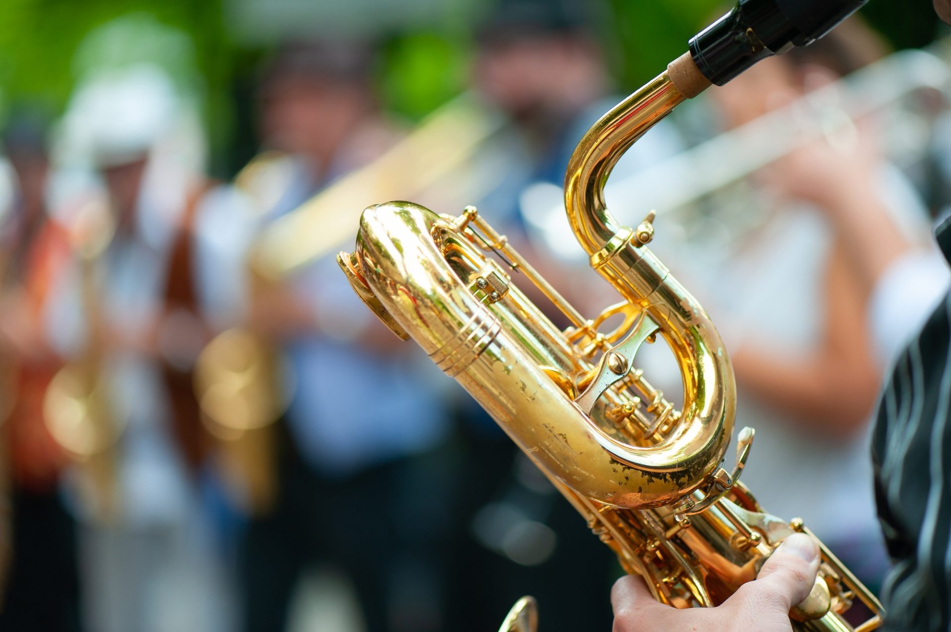 Saxophone alto doré tenu par un musicien en costume